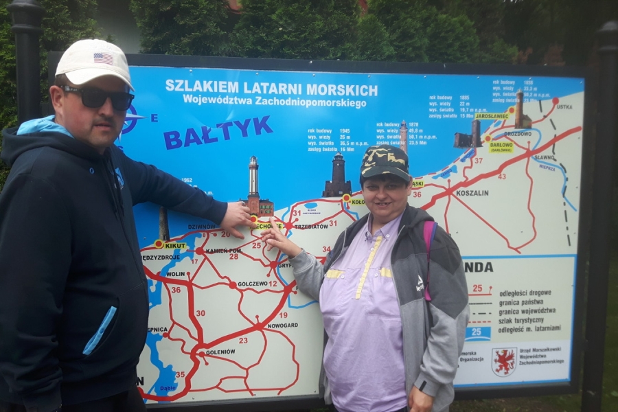 Dwójka uczestników wskazujących punkt na tablicy z mapą.