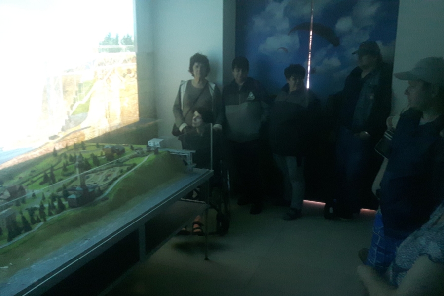 Grupa uczestników podziwiających makietę.