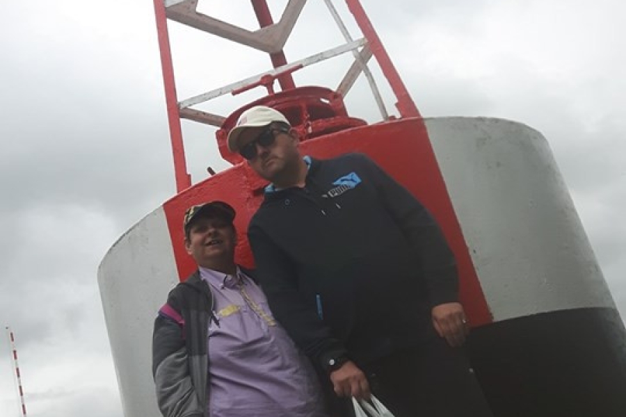 Dwójka uczestników na tle sygnalizatora morskiego.