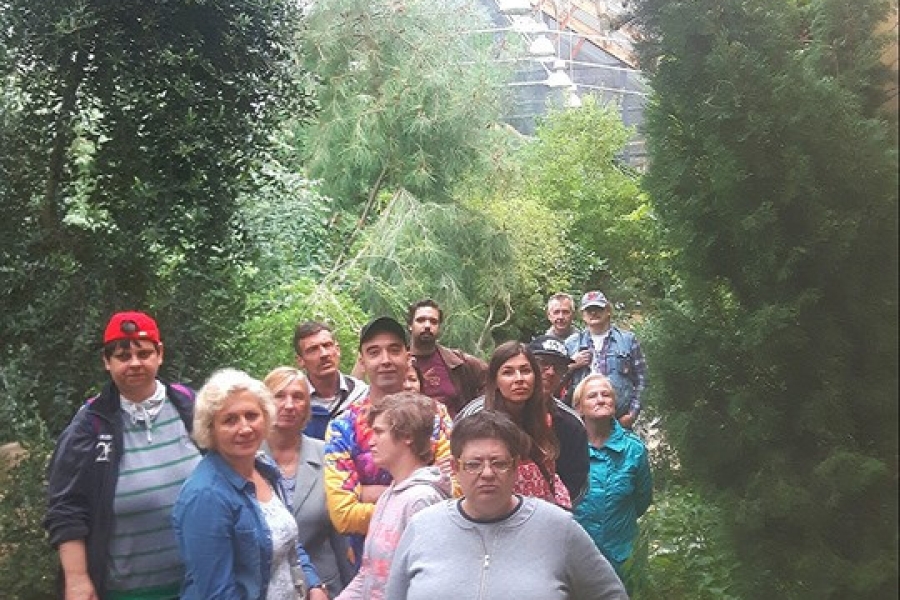 Uczestnicy pozują do zdjęcia w szklarni.