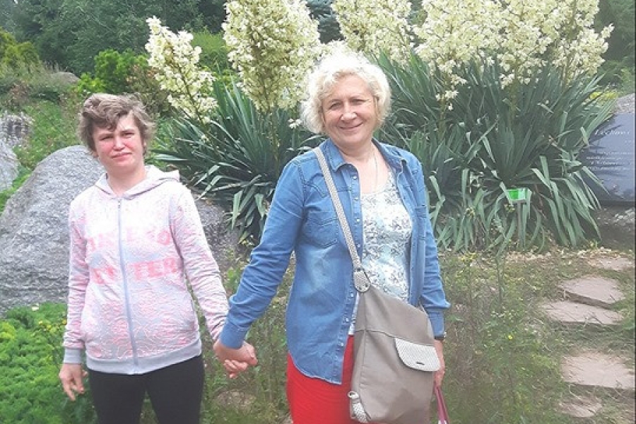 Uczestniczka z mamą na tle ogrodu.