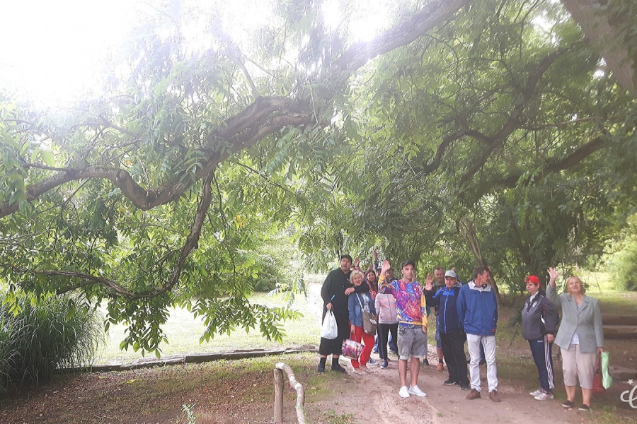 Grupa uczestnika stojących pod wierzbą.