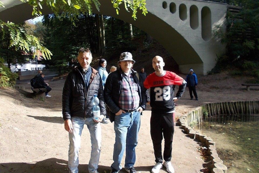 Uczestnicy na tle kładki przy jeziorze szmaragdowym