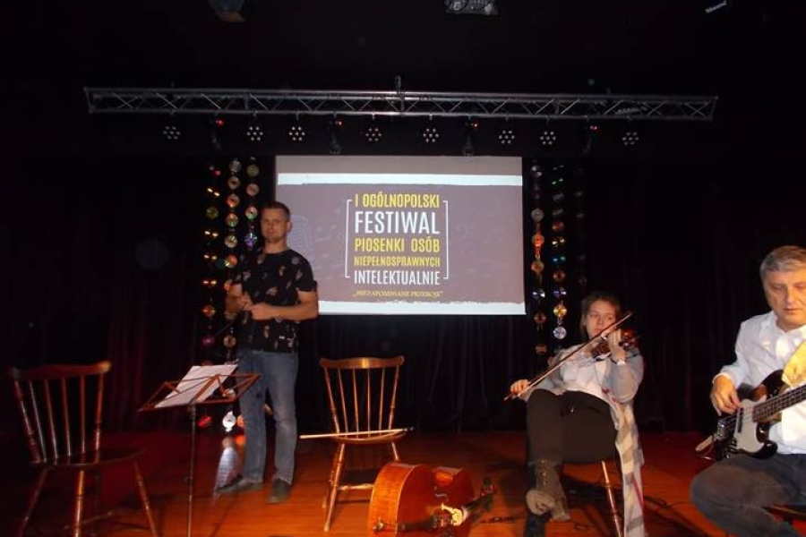 Muzycy podczas występu na scenie na tle prezentacji