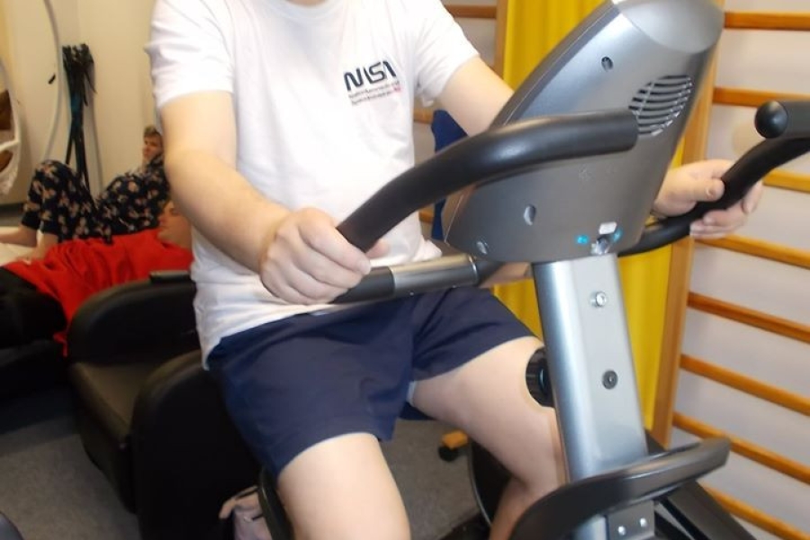 Uczestnik ćwicząc na rowerze stacjonarnym