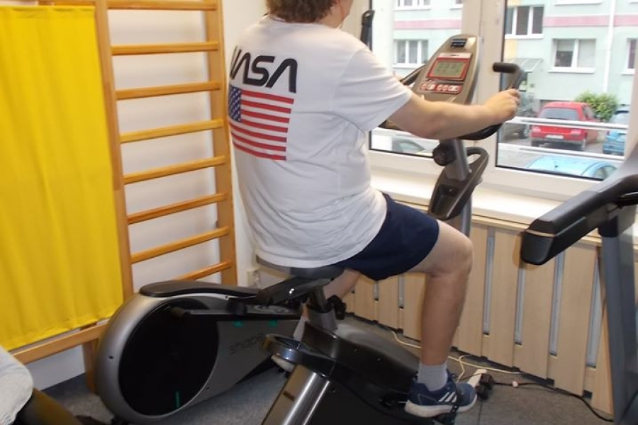 Uczestnik ćwiczący na rowerze stacjonarnym