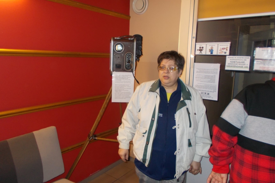 Uczestniczka stojąca przy zabytkowym projektorze 