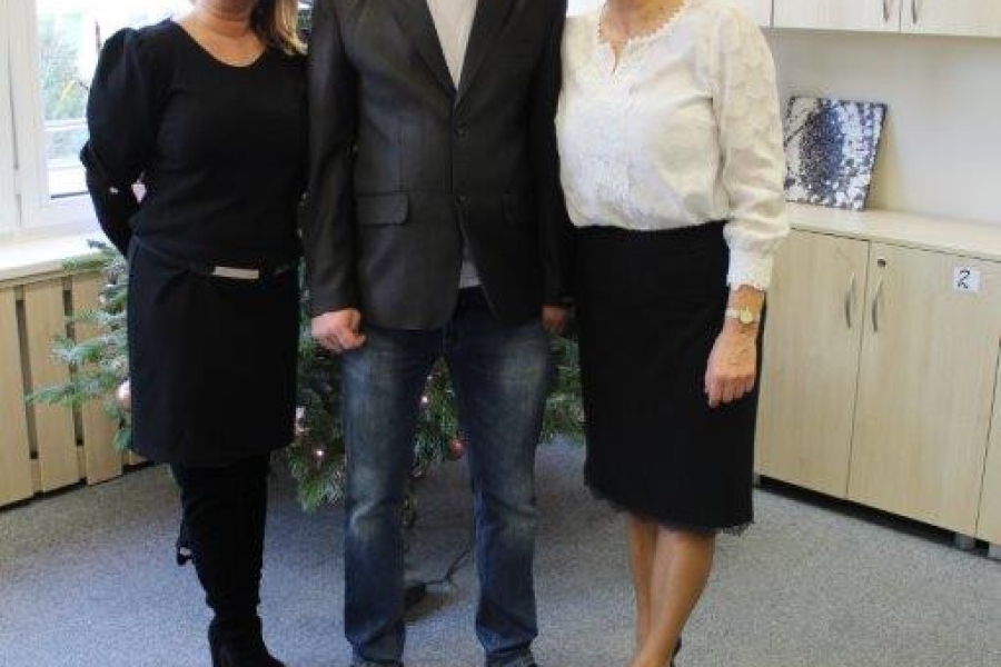 Uczestnik, terapeutka oraz kierownik ŚDS  na tle choinki