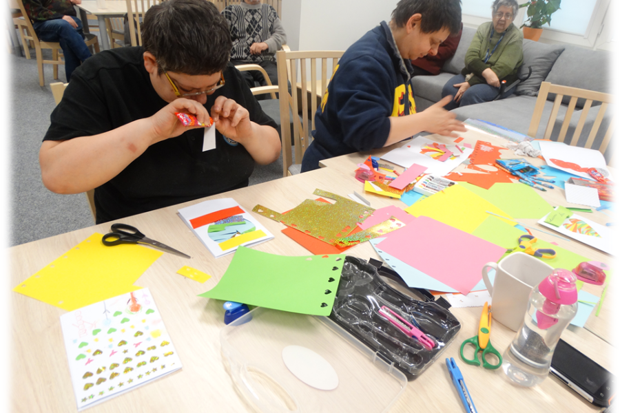 Dwie uczestniczki w trakcie naklejania kolorowych bibułek