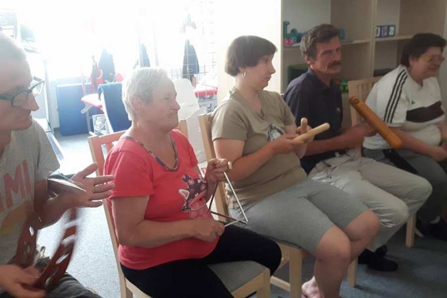 Grupa uczestników zajęć muzycznych w trakcie ćwiczeń na instrumentach perkusyjnych