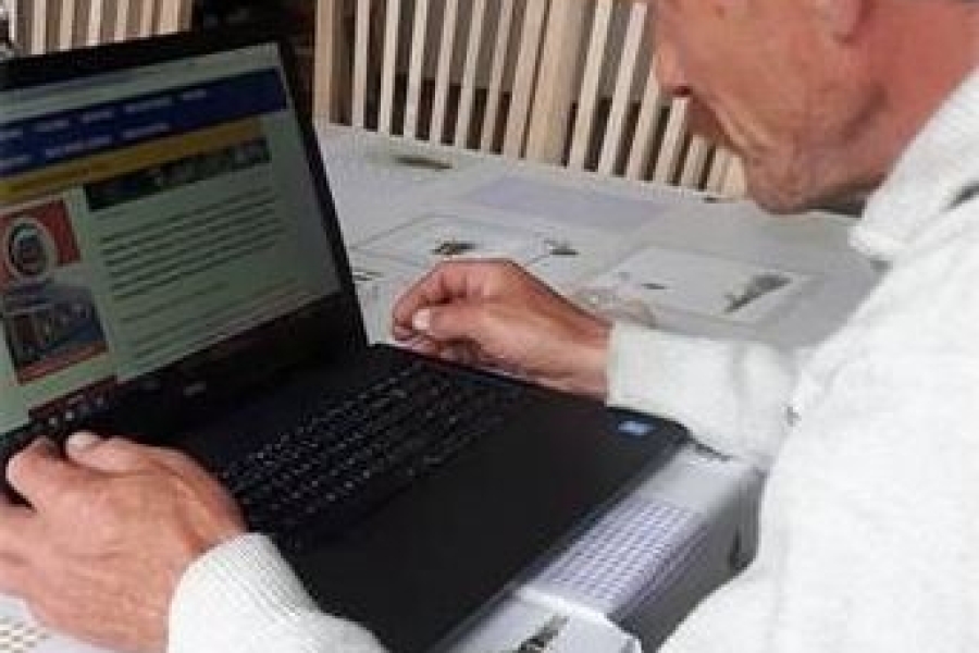 Uczestnik w trakcie przeglądania prasy internetowej na laptopie