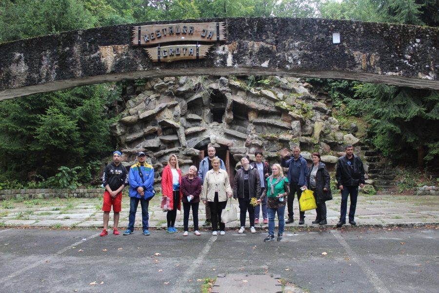 7 – Uczestnicy wraz z terapeutami pozują do zdjęcia na tle Groty Goeringa. 