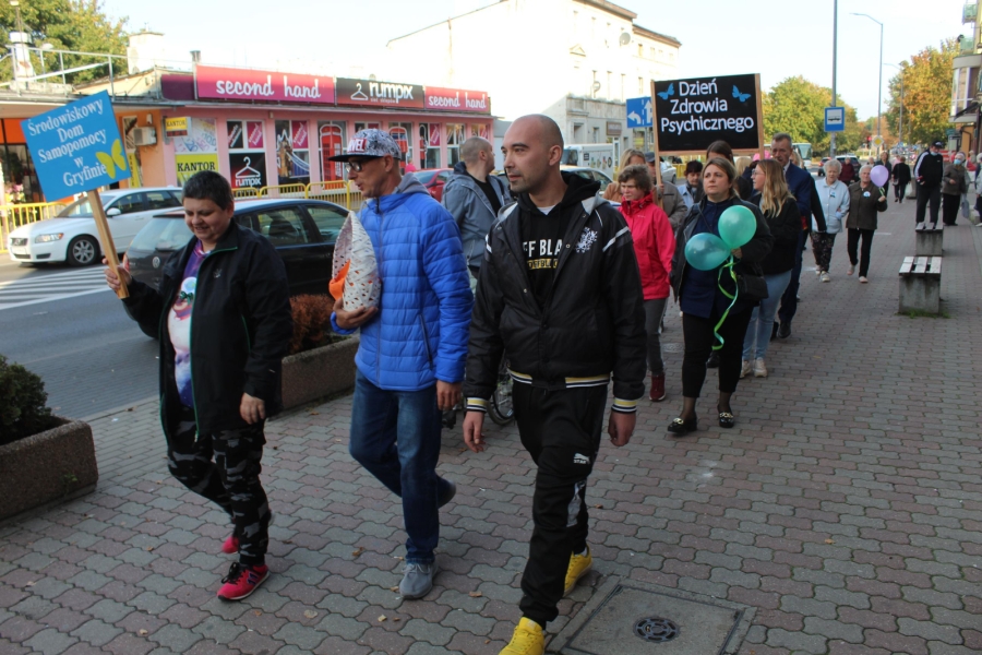 2 – Uczestnicy wraz z terapeutami maszerujący ulicami Gryfina trzymają transparenty z hasłami.