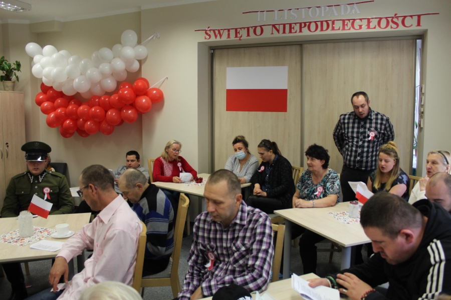 11 – Uczestnicy oraz zaproszeni goście śpiewają pieśni patriotyczne na tle balonów w kształcie flagi. 