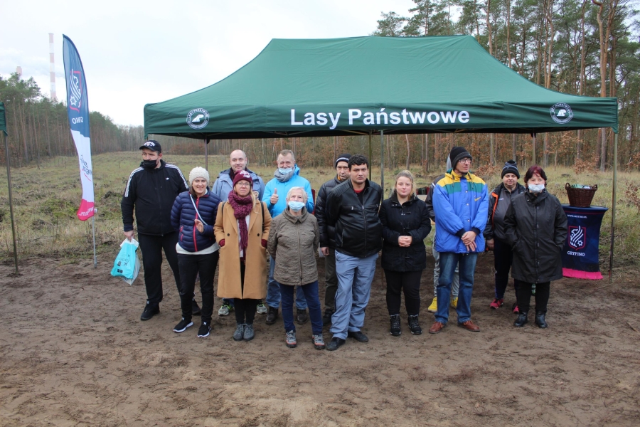 1 – Grupa Uczestników wraz z terapeutami pozują do zdjęcia na tle namiotu.