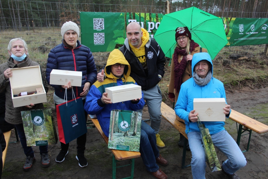 4 – Uczestnicy prezentują otrzymane nagrody na tle banera. 